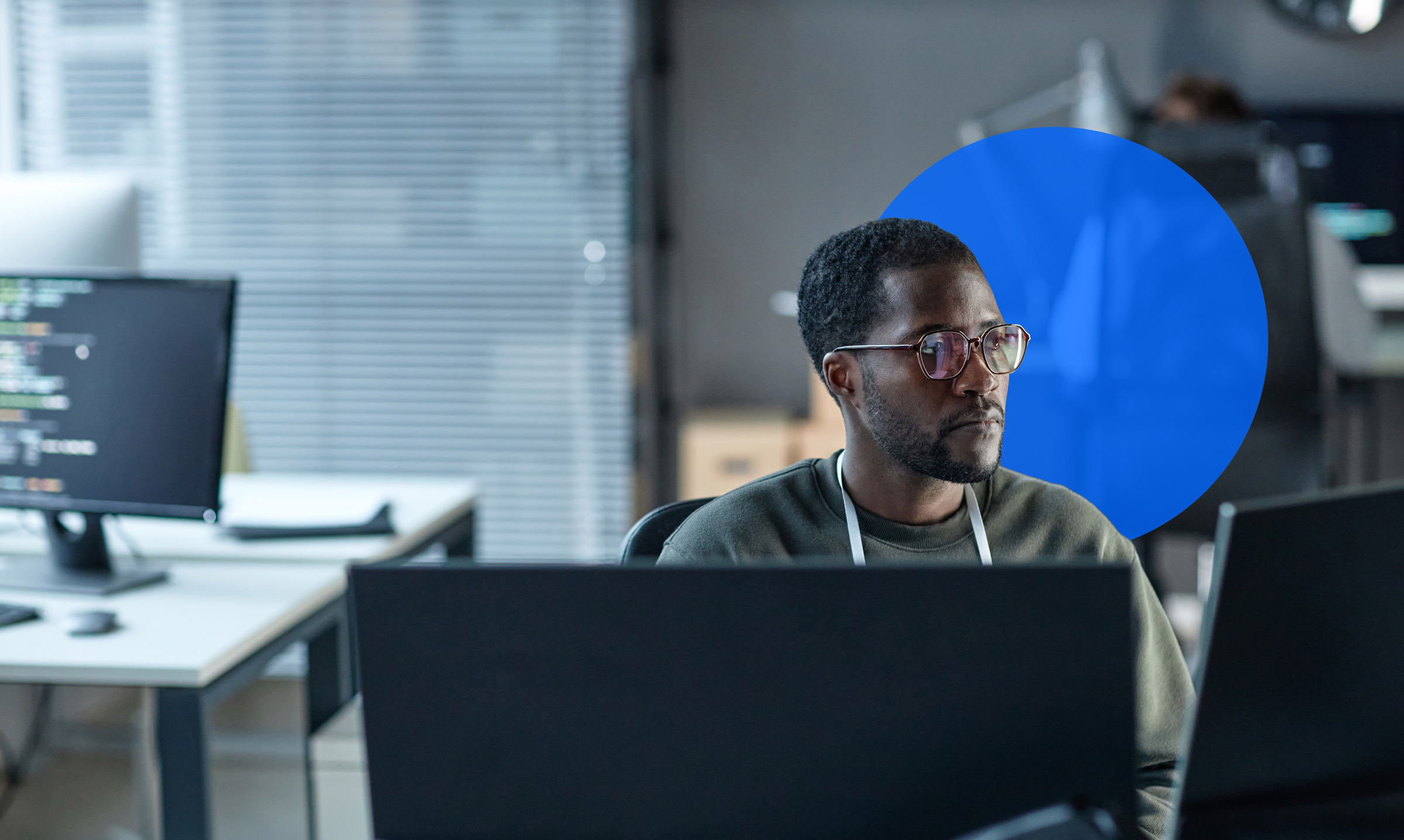 A man looks at multiple monitors