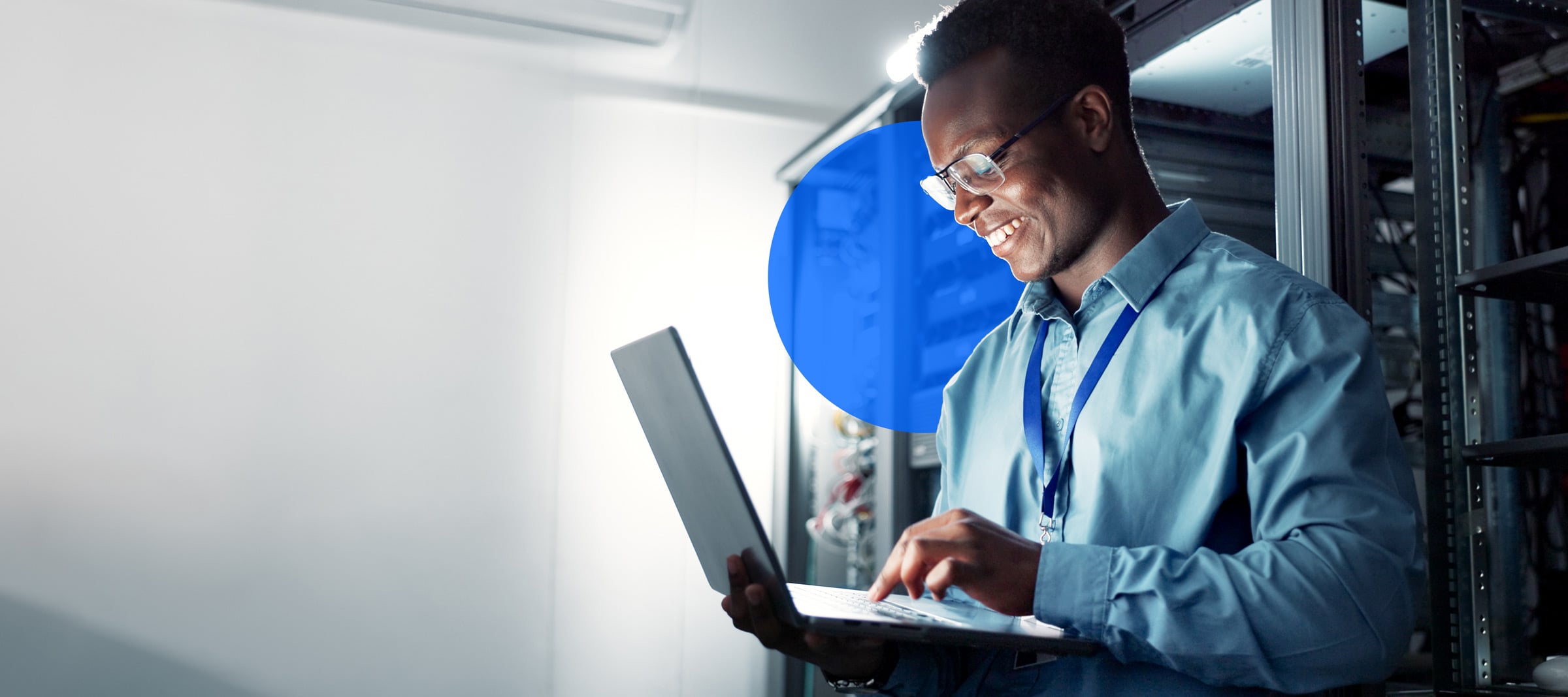 A man smiles while looking at a laptop