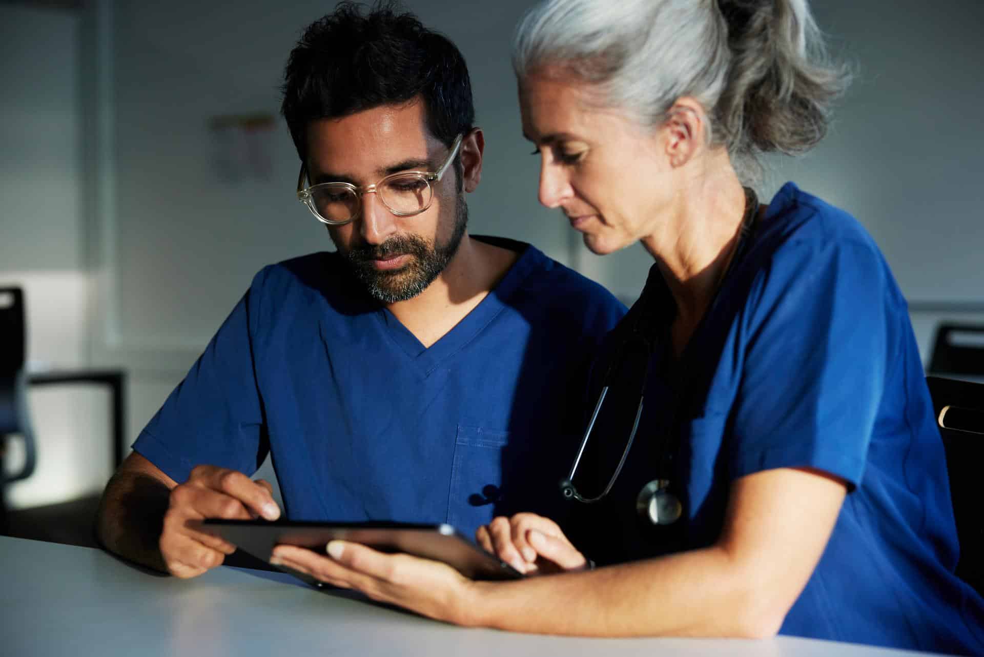 Compañeros sanitarios utilizando una tablet y mirando la pantalla - Healthcare colleagues using a tablet and looking at the screen