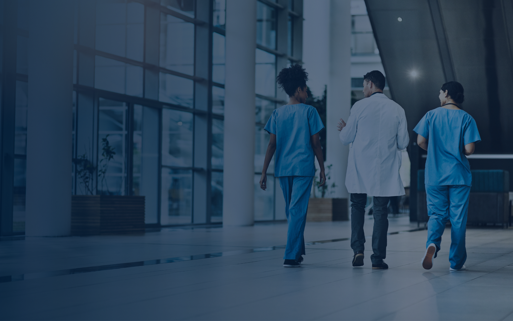 Healthcare professionals walking through a modern hospital corridor representing collaboration enabled by a federated data platform.