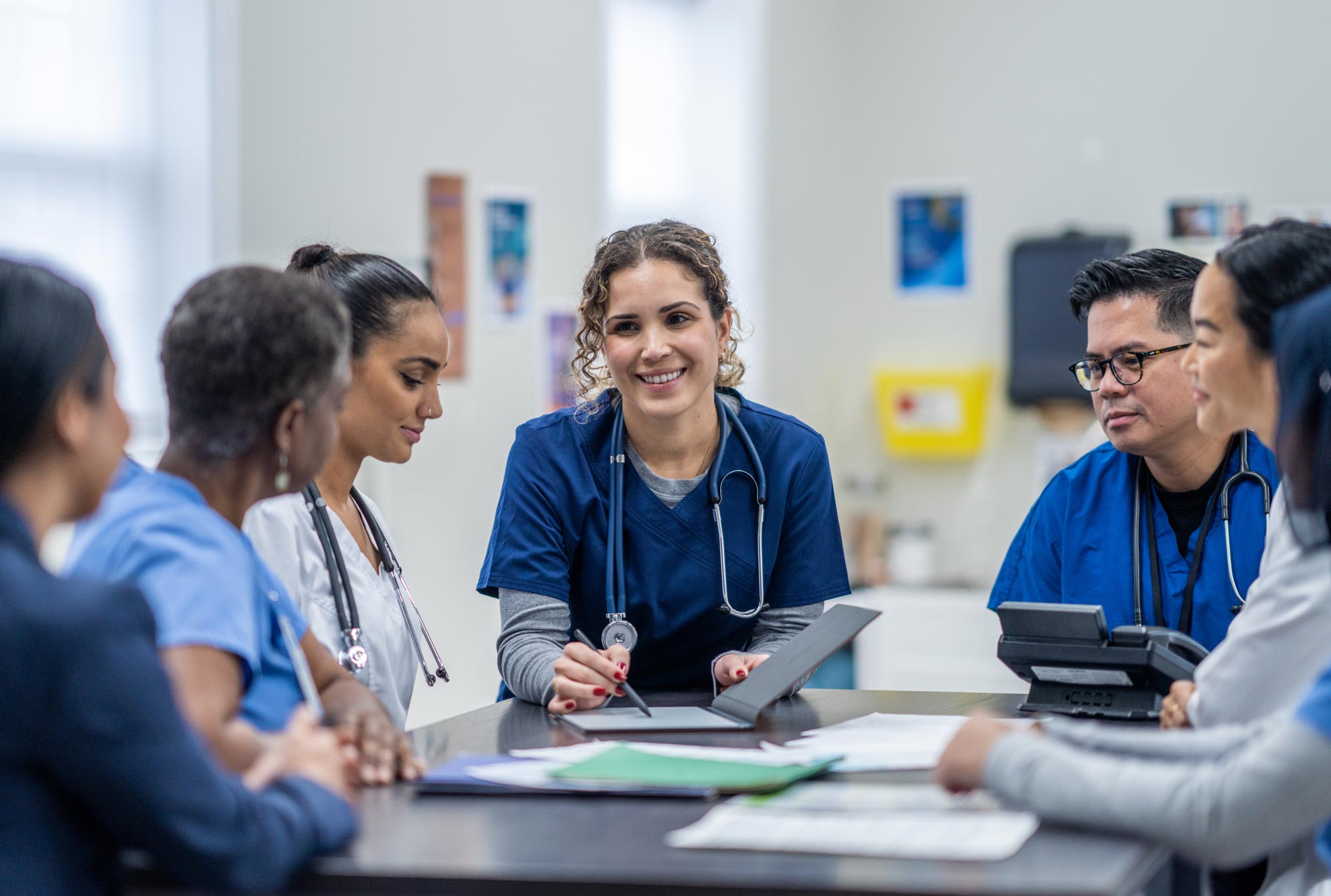 Several healthcare professionals having a conversation around a meeting table