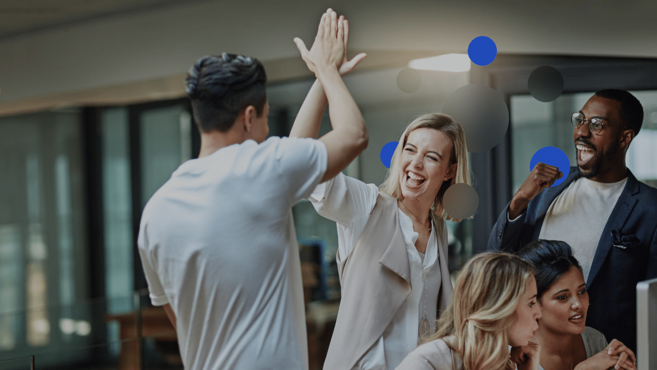 A group of professionals celebrating and high-fiving each other to help illustrate Telefonica Tech's awards and accreditations.