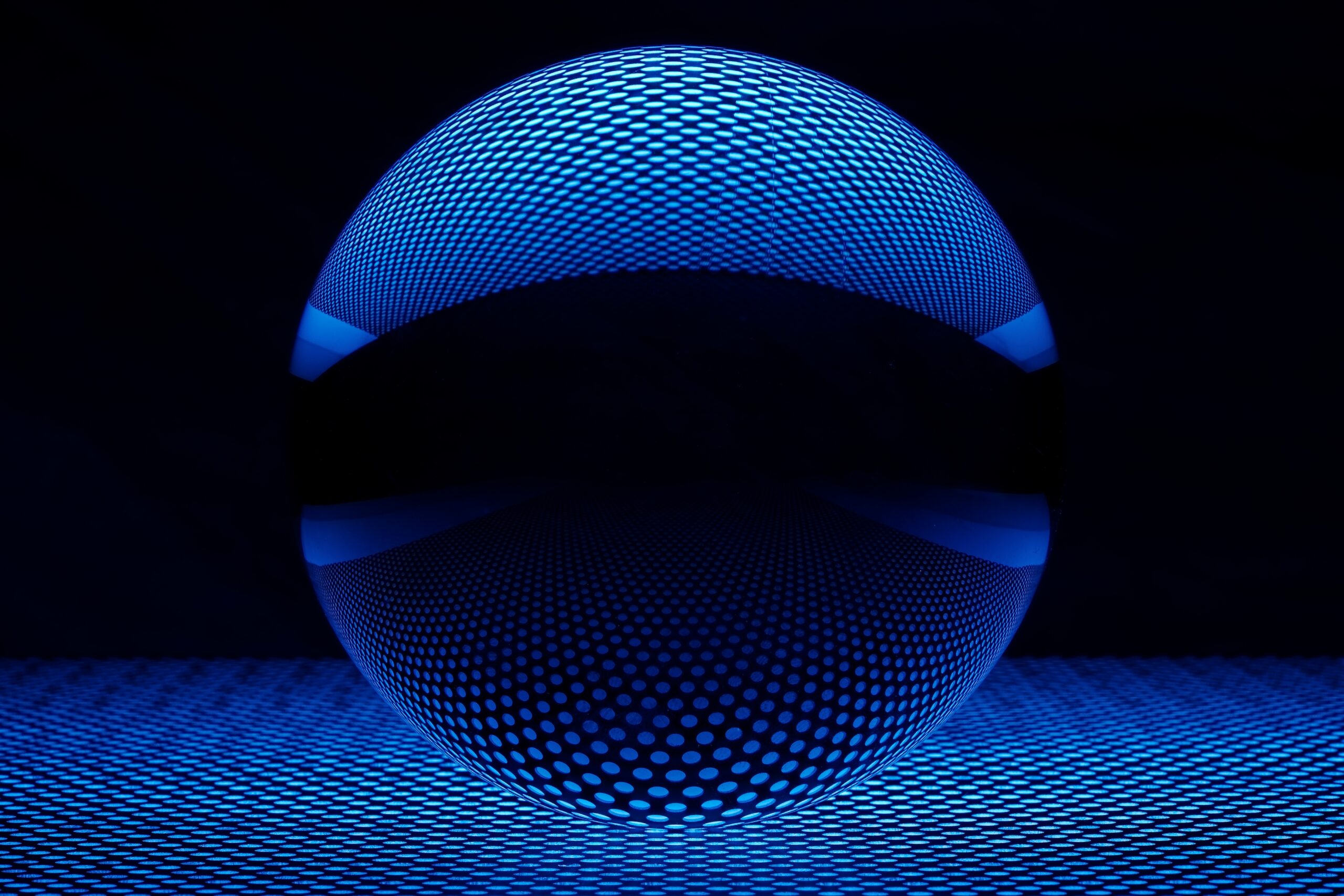 A closeup shot of crystal ball reflecting the lights below it with a dark background