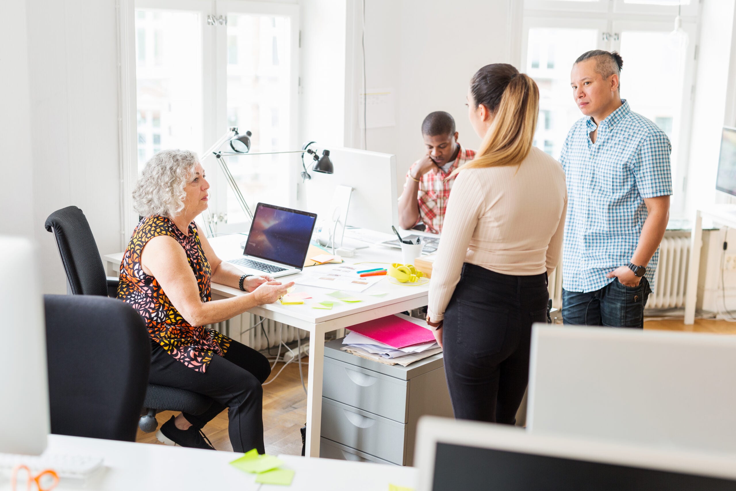 Team discussing data governance policies, data stewardship and business processes in a collaborative office environment.