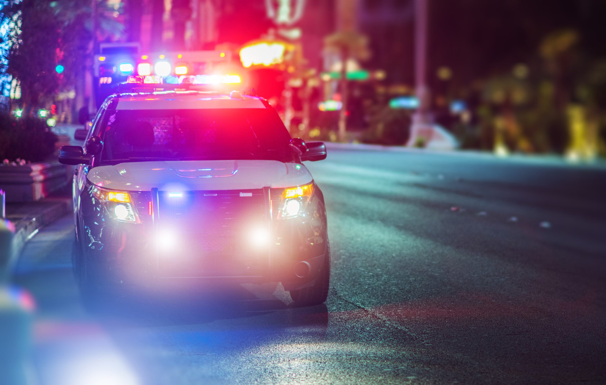 Police car with flashing lights at night illustrating predictive policing powered by Databricks Genie and AI analytics