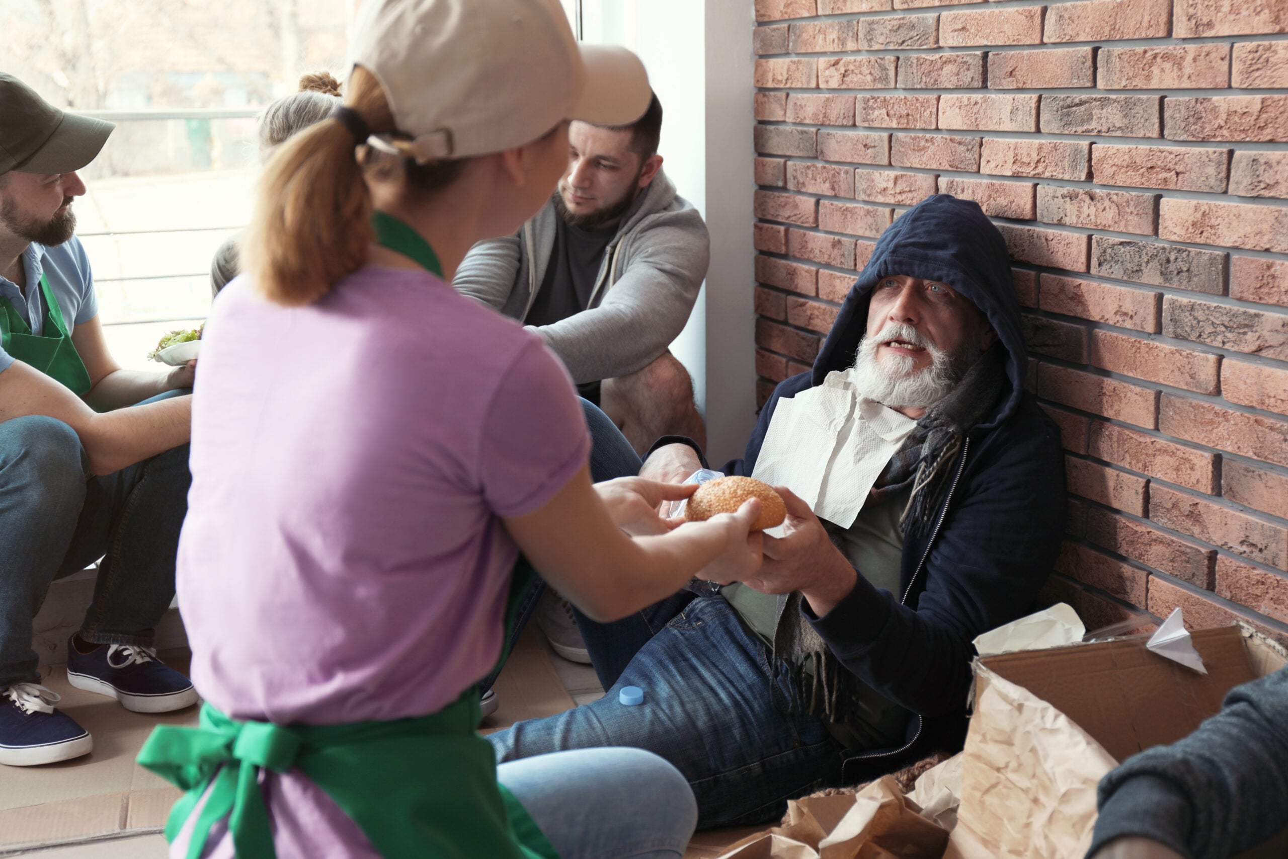Volunteer providing food and support to a person experiencing homelessness