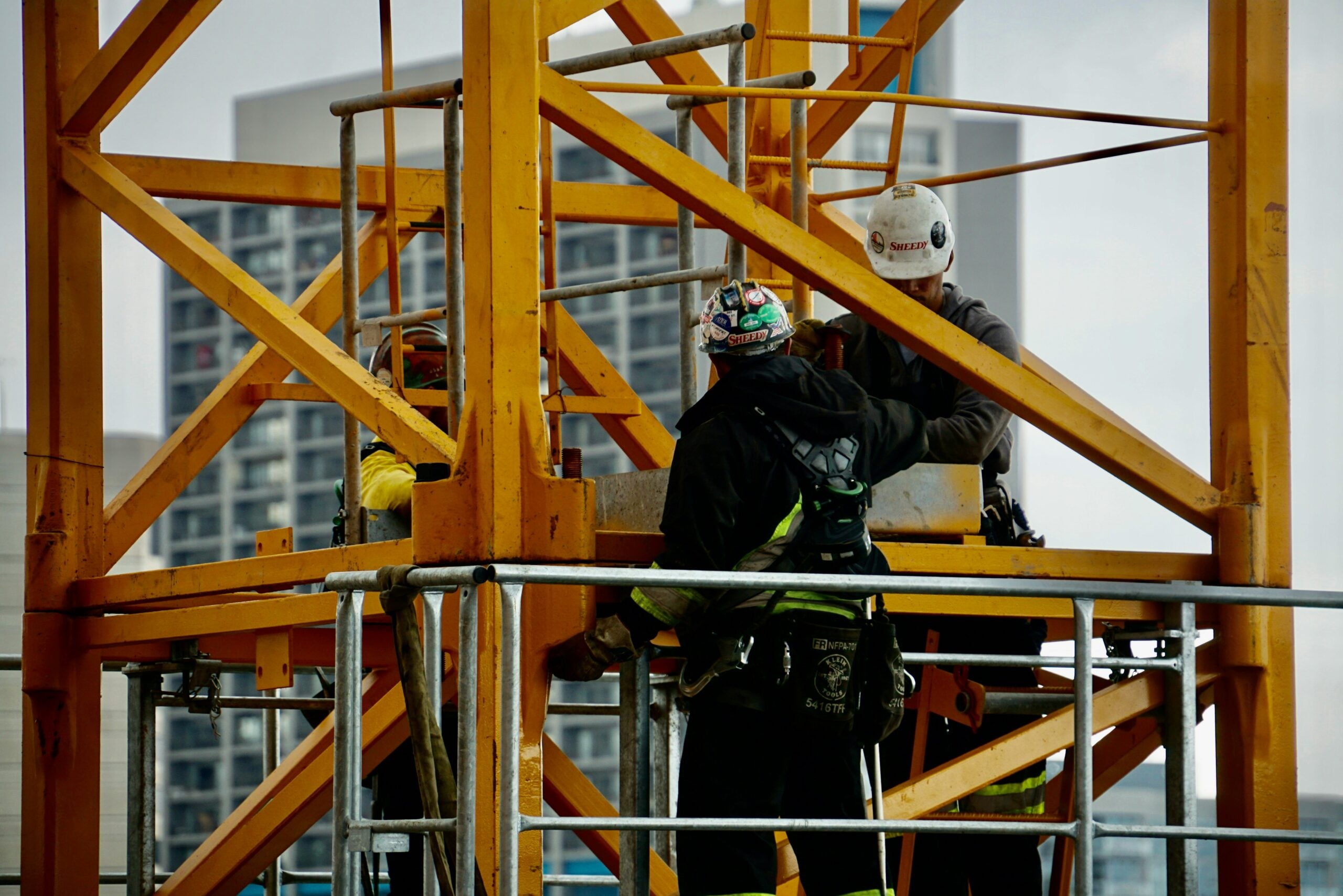 The image shows three people working on a construction site