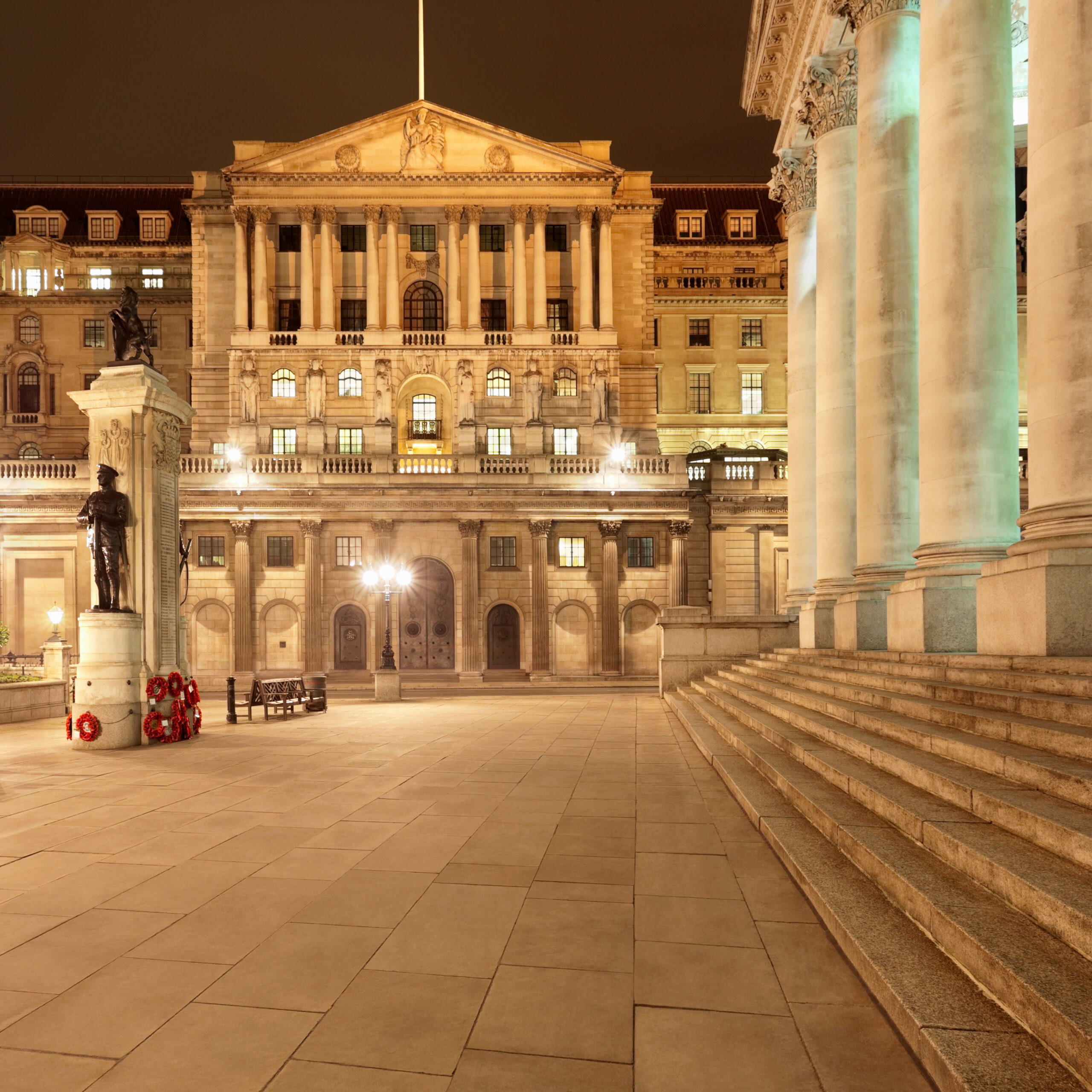Historic civic buildings and public square illuminated at night