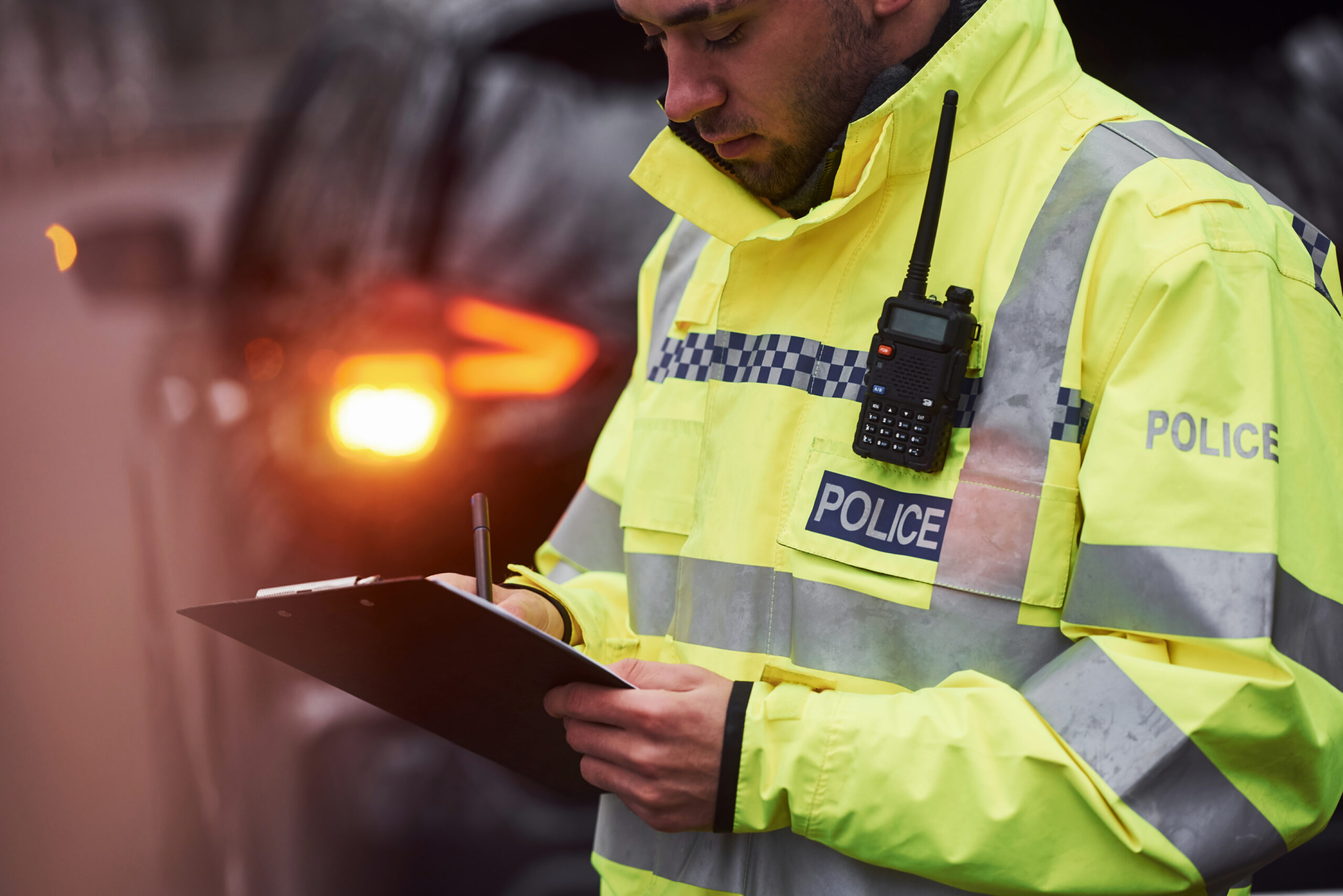 Police officer completing paperwork as part of a Clare’s Law risk assessment related to domestic abuse prevention.