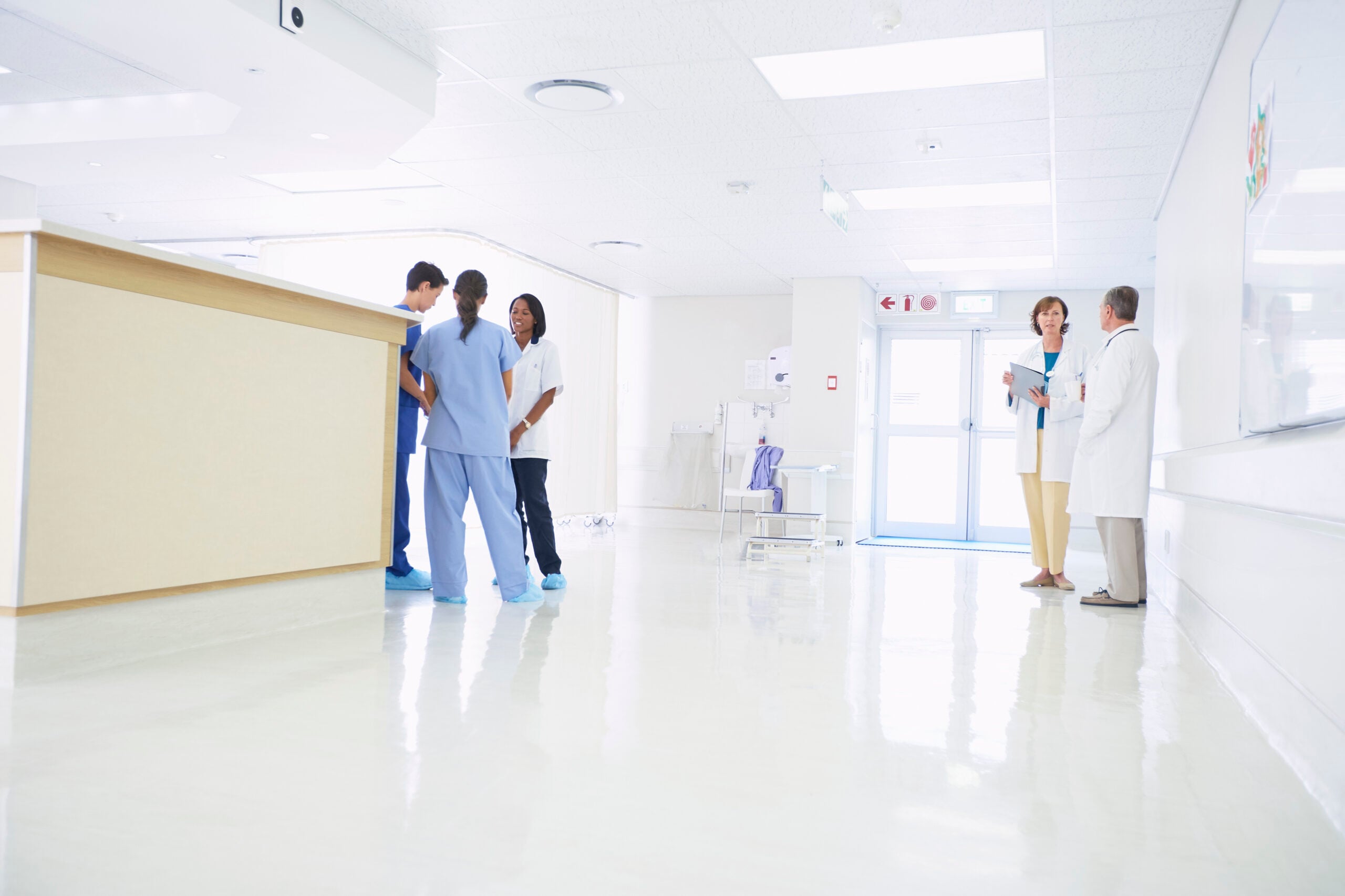 Doctors and nurses discussing patient care at nurses station NHS Federated Data Platform